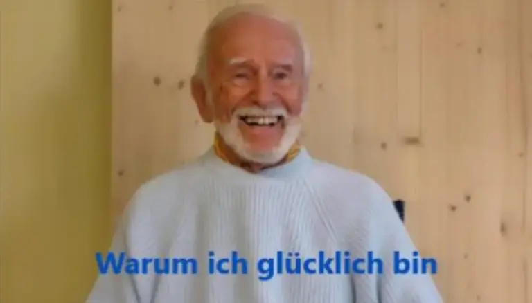 Kurt Tepperwein in hellem Pullover lacht, darüber der Schriftzug „Warum ich glücklich bin“